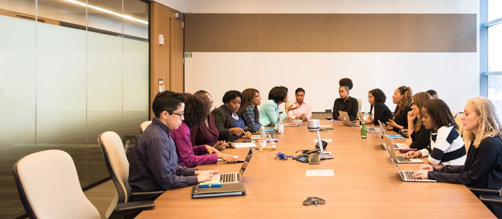 A large team of employees meeting around a conference table