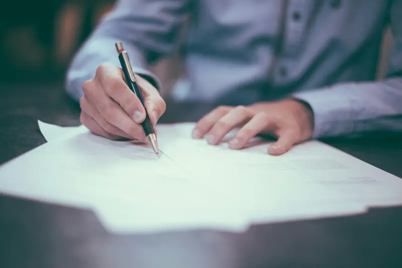 A business owner signing forms at a desk